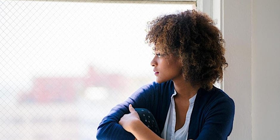 a woman sitting by the window enjoying alone time